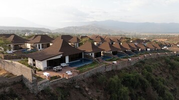Un resort con varias edificaciones tipo cabaña, cada una con piscina privada y zona de estar al aire libre.