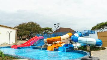 A water park with multiple slides and a swimming pool.