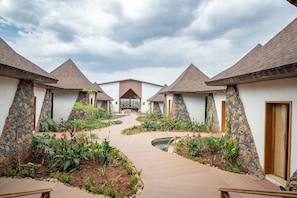 A courtyard with a central pathway leading to a building with a peaked roof.