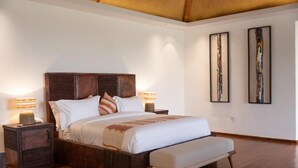 A bedroom with a large bed, wooden headboard, bedside lamps, and two abstract paintings on the wall. - Kuriftu Resort & Spa Arba Minch  (Arba Minch)