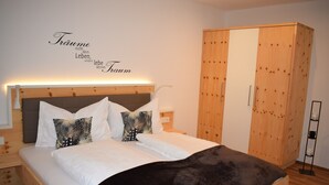 A bedroom with a bed, pillows, a wardrobe, and a wall with text. - Apartment 'Residence Ladurn Herz' with Mountain View, Balcony and Wi-Fi (Tirol)