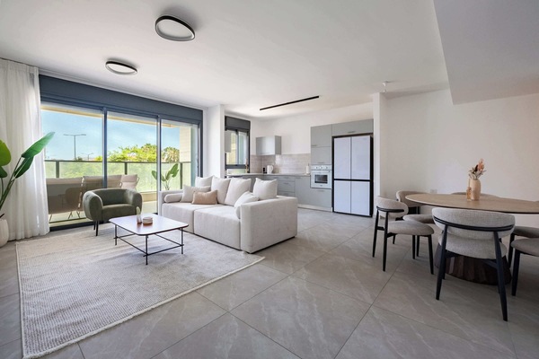 Airy multipurpose space flowing effortlessly between living, cooking, and entertaining zones throughout apartment.