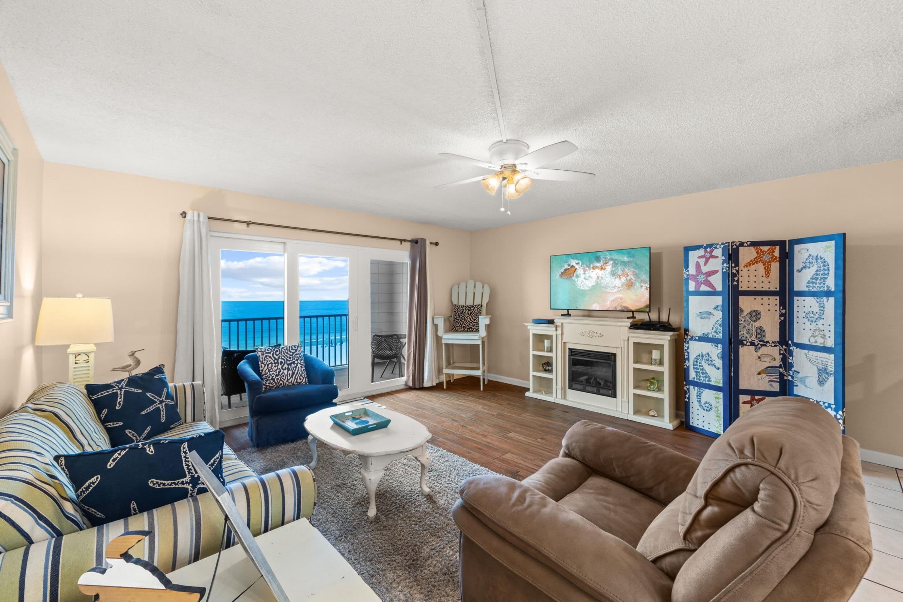 A living room with a sofa, armchair, and a coffee table. There is a fireplace and a painting on the wall.