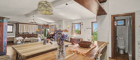 A spacious kitchen with a wooden island, a hanging light fixture, and a view to the dining area.