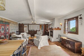 A cozy living room with a fireplace, wooden furniture, and a rustic decor. - Casa Bike and Hike Camino Teide: Sea Views, Shared Terrace & Wi-Fi (Vilaflor)