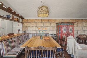 Ein Essbereich mit Holztisch, Sitzbänken und einer Steinsäule.