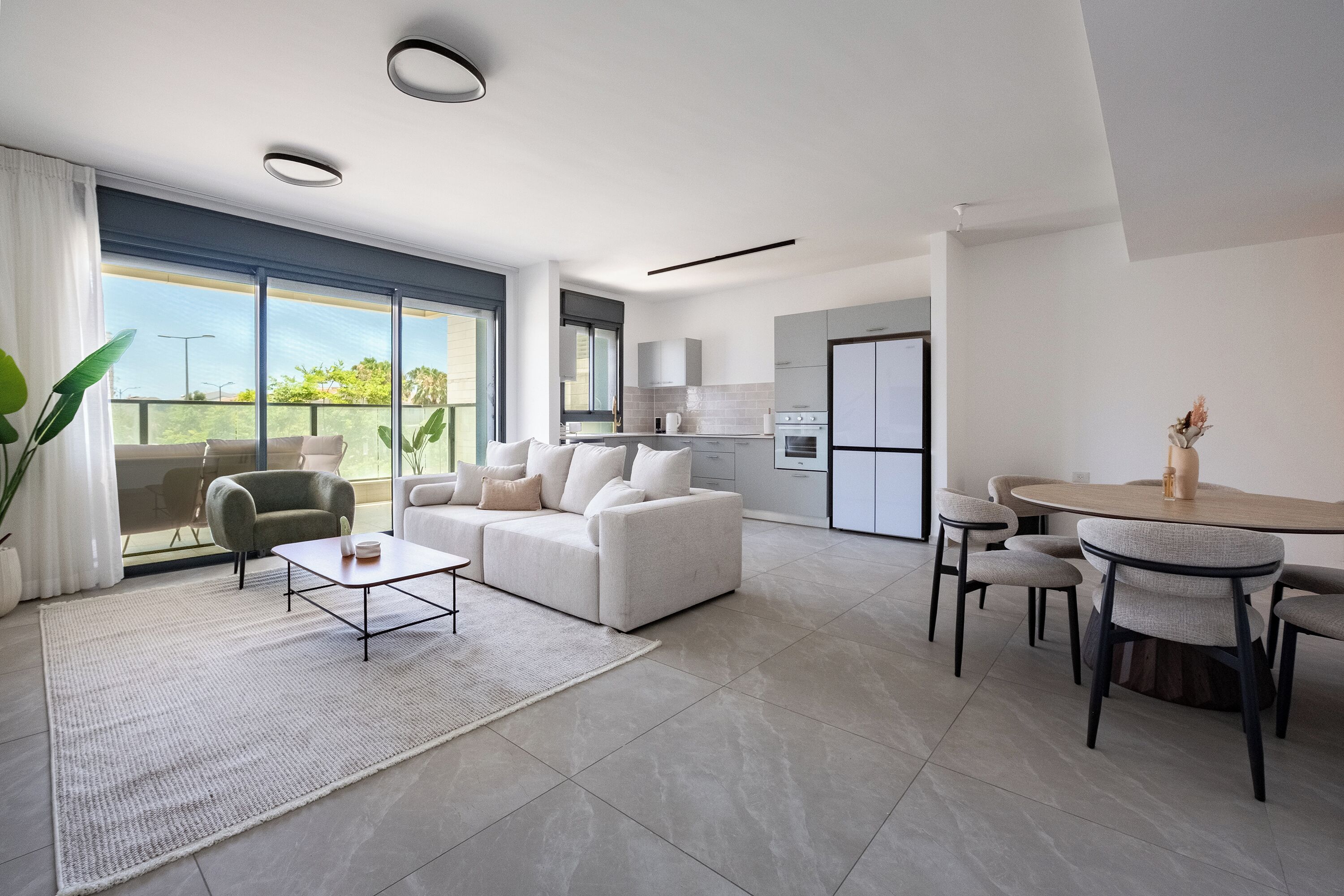 Un salon moderne comprenant un canapé, une table basse et un coin repas avec des chaises et une table.