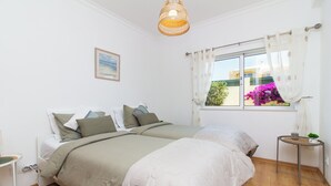 Ein Schlafzimmer mit Bett, Nachttisch und einem fenster mit Vorhängen.