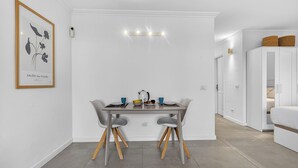 Un comedor moderno con una mesa, sillas y un cuadro en la pared.