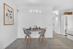 A modern dining area with a table, chairs, and a framed artwork on the wall. - Home Holidays 114 (CN)