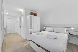 A hotel room with a bed, bedside lamps, a wardrobe, and a bathroom door. - Home Holidays 114 (CN)