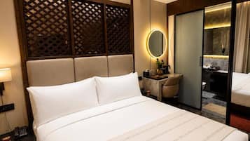 Una habitación de hotel con una cama grande, una mesita de noche y un espejo.