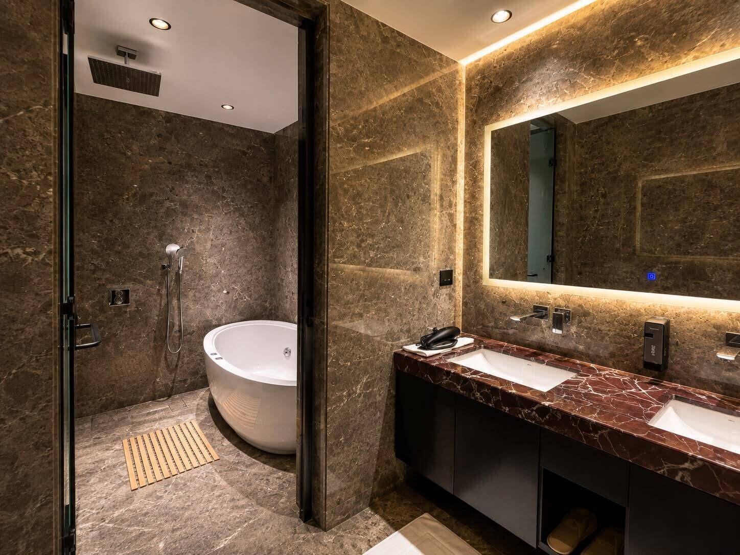 A modern bathroom with a freestanding bathtub, a large mirror, and a marble countertop.