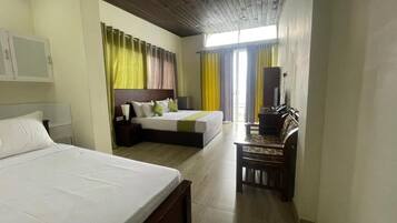A hotel room with two beds, a desk, a chair, and a television.