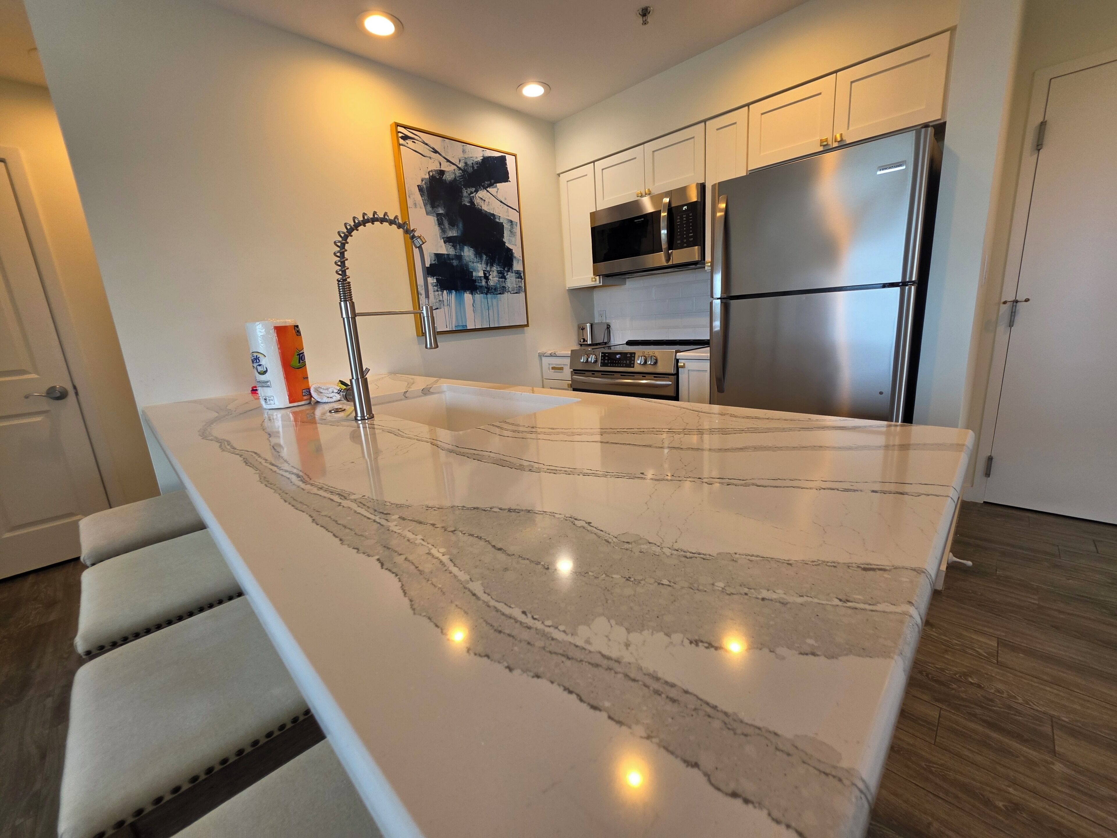 A modern kitchen with a large island, stainless steel appliances, and a minimalist design.