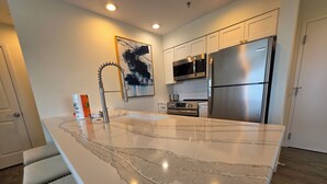 Una cocina moderna con una isla grande, electrodomésticos de acero inoxidable y un diseño minimalista.