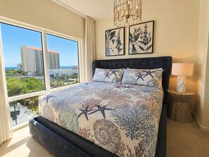 Une chambre d’hôtel avec un grand lit, une vue sur la ville et un lustre.