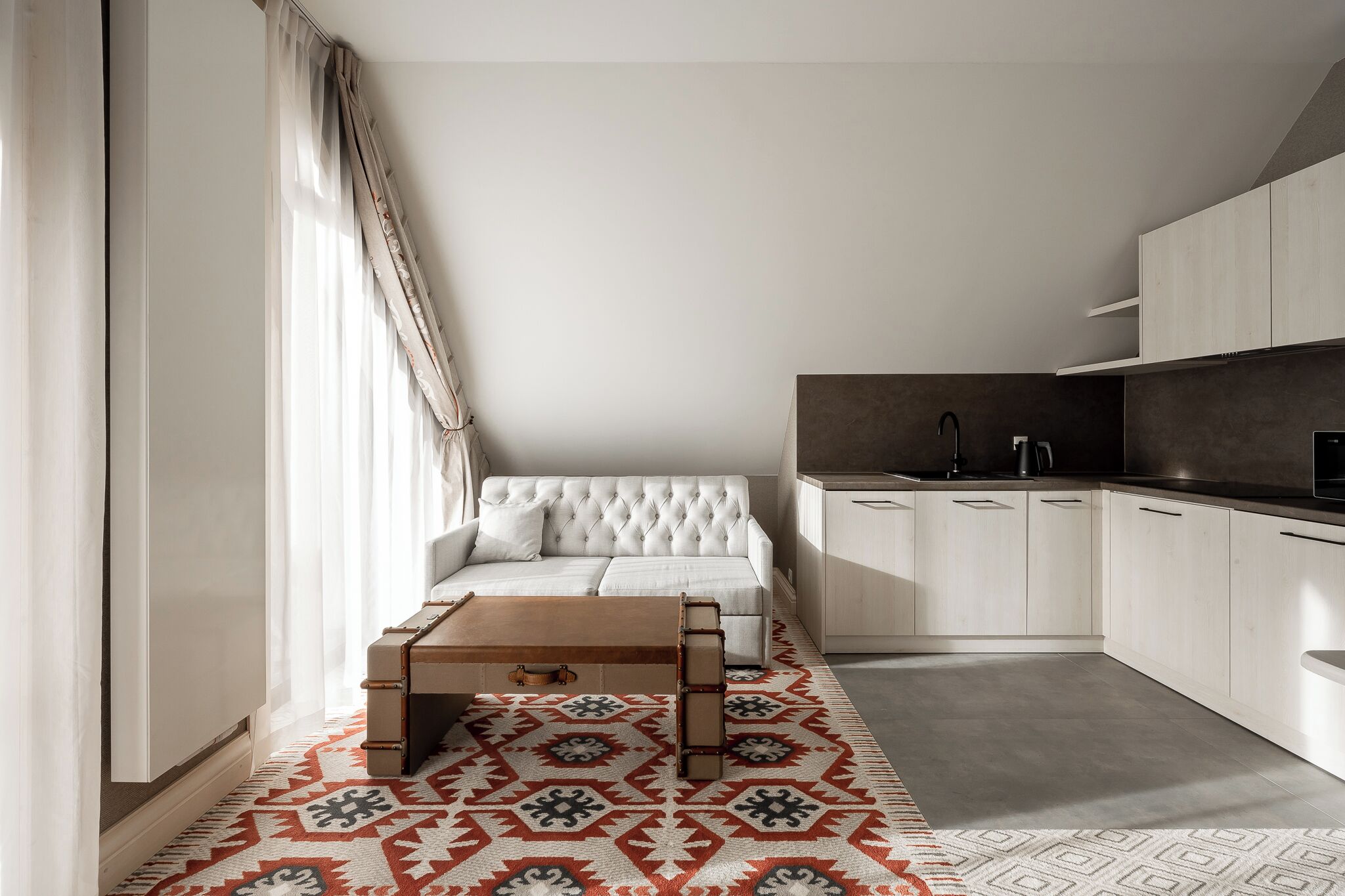 A modern living room with a sofa, coffee table, and patterned rug.