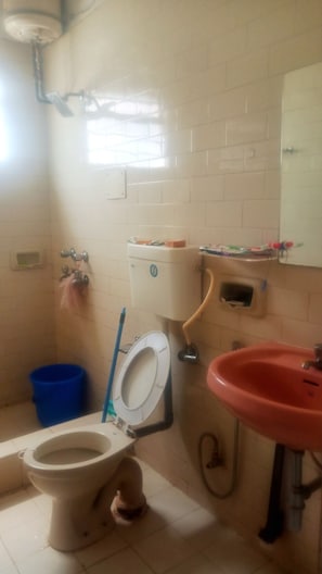 Un bany amb vàter, rentamig i finestra.
