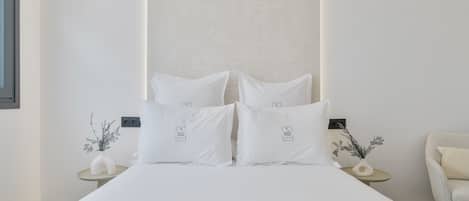 A neatly arranged bedroom with a bed, two bedside tables, and a chair.