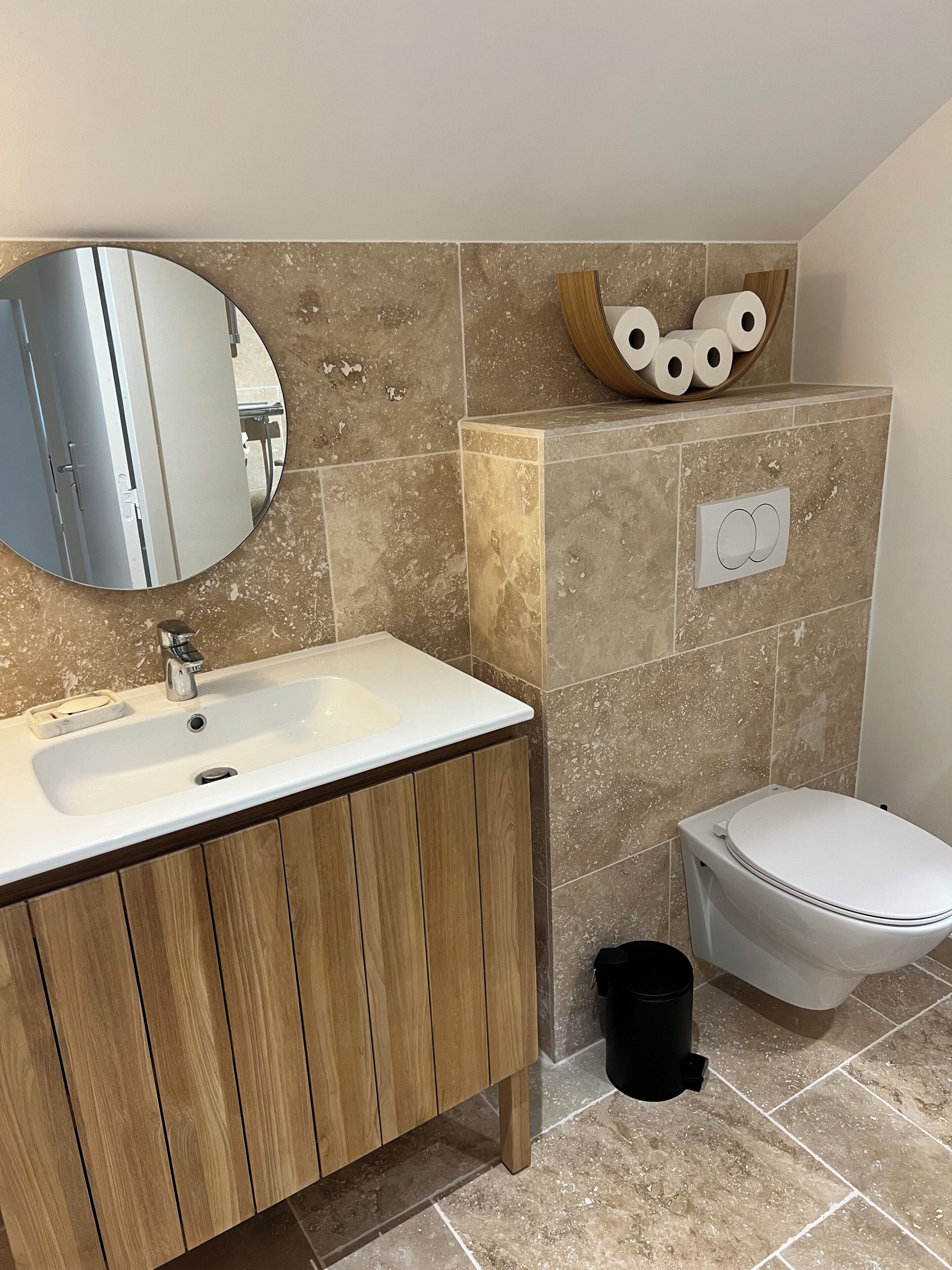 Ein Badezimmer mit Waschbecken, Spiegel, Toilette und Mülleimer.