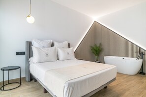 Un dormitorio moderno con cama, mesita de noche y bañera independiente.