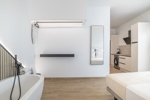 Une salle de bain moderne équipée d’une baignoire, d’une douche, de toilettes et d’un lavabo.