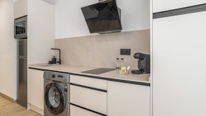 Uma cozinha moderna com máquina de lavar embutida, micro-ondas e máquina de café.