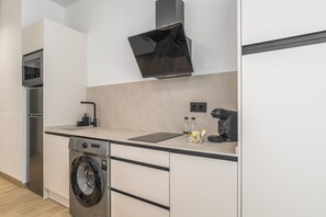 Eine moderne Küche mit Waschmaschine, Mikrowelle und Kaffeemaschine.