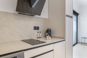Une cuisine moderne équipée d’un lave-vaisselle intégré, d’une machine à café et d’un distributeur d’eau.