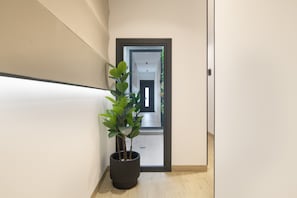 A hallway with a potted plant, a door, and a view into another room. - Studio Apartment '103' with Wi-Fi and Air Conditioning (Conil de la Frontera)