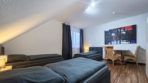 A hotel room with two beds, a desk, and a chair. - Alpha Apartments: Grand Space | 6 Beds & Parking (Datteln)