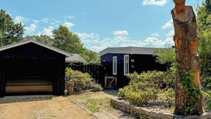 A property with a garage, a wooden sculpture, and a building with a number '62' on it. - 4 Star Holiday Home in Ans By (Ans)