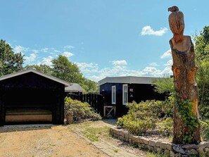 Ein Anwesen mit Garage, einer Holzskulptur und einem Gebäude mit der Nummer 62.