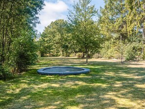 A circular trampoline in a grassy area surrounded by trees. - 4 Star Holiday Home in Ans By (Ans)