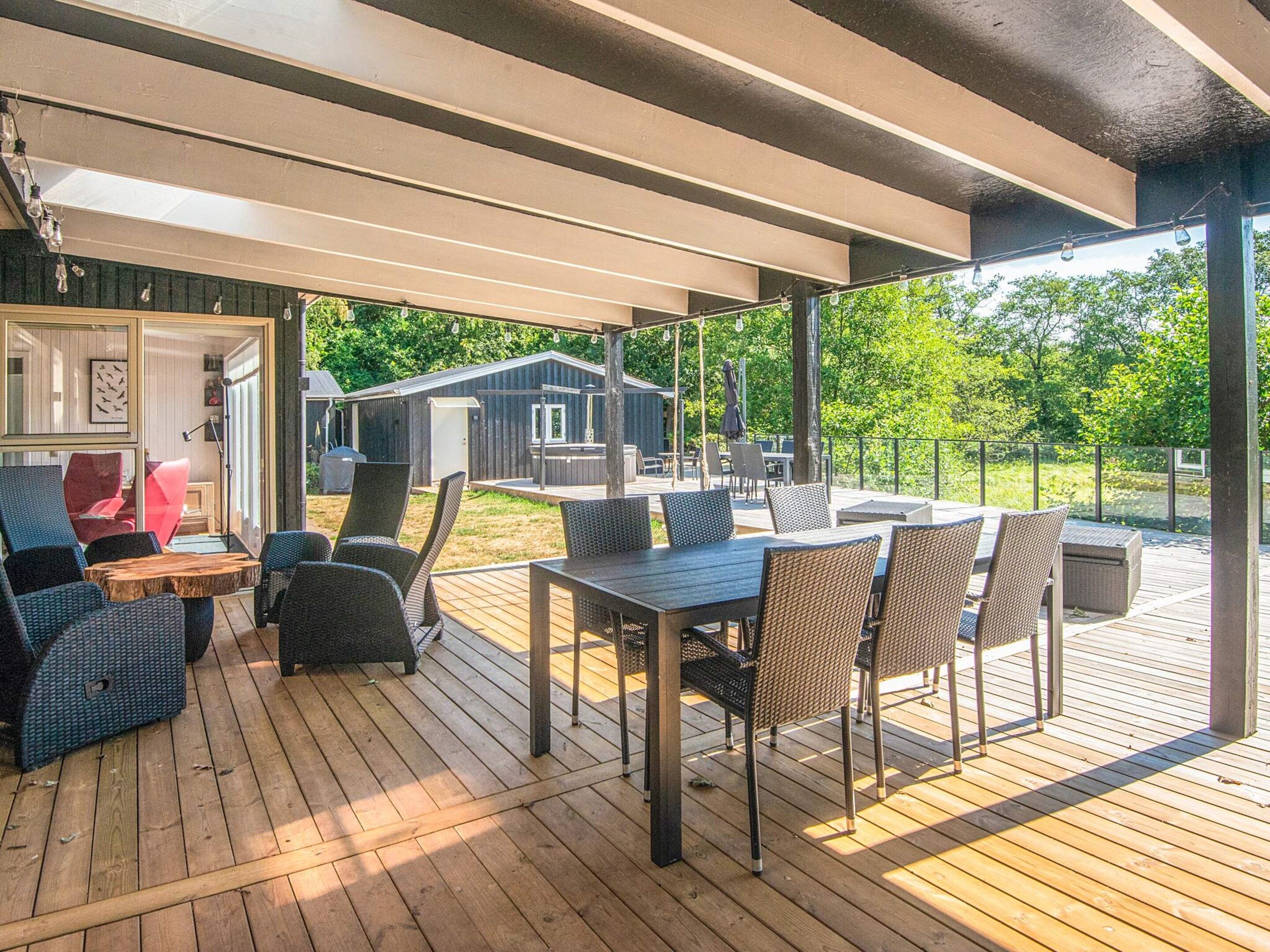 Ein Außenbereich mit Terrassenausstattung, Korbmöbeln und Blick auf ein Wohngebäude im Hintergrund.