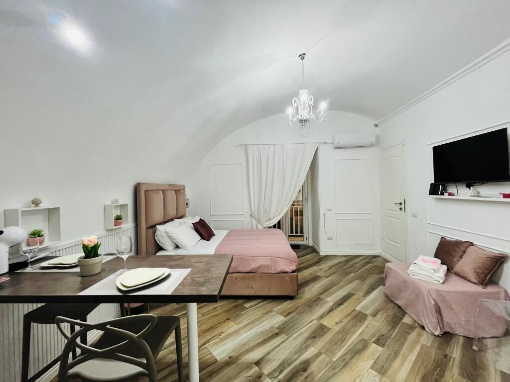 A modern bedroom with a bed, bedside table, and a TV.