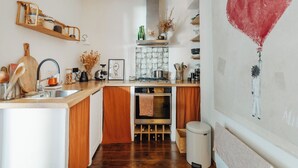 A kitchen with wooden cabinets, a built-in oven, a sink, and a stove. - Guéthary: Between the Ocean and the Village, Terraces, and Gardens (Guéthary)