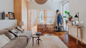 A cozy living room with a sofa, a coffee table, and a dining area with chairs and a table. - Guéthary: Between the Ocean and the Village, Terraces, and Gardens (Guéthary)
