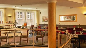 En hotellobby med en central søjle, siddepladser og en bar.