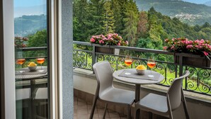 A balcony with a table and chairs, a railing, and a view of a mountainous landscape. - Rota Suites (Rota D'Imagna)