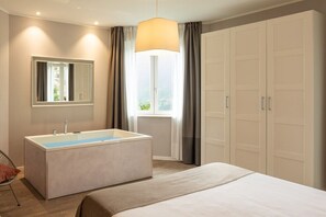 Ein modernes Schlafzimmer mit einem großen Bett, einer integrierten Badewanne, einem Spiegel und einem Kleiderschrank.