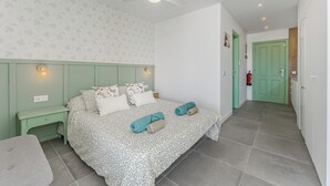 A bedroom with a bed, nightstands, a ceiling fan, and a green door. - Home Holidays 423 (CN)