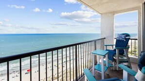 Een balkon met uitzicht op het strand en de oceaan.