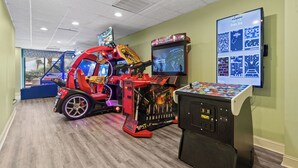 Een speelhal met diverse spelautomaten, waaronder een racegame en een spel met een ruimtevaartthema.