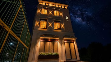 Un edificio de dos pisos con ventanas iluminadas y un cartel que dice 'The Leaf'.