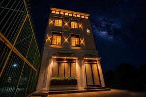 A two-story building with illuminated windows and a sign that reads 'The Leaf.' - THE LEAF HOTEL (Ludhiana)