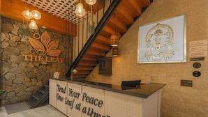 A reception area with a stone wall, wooden ceiling, and a reception desk.