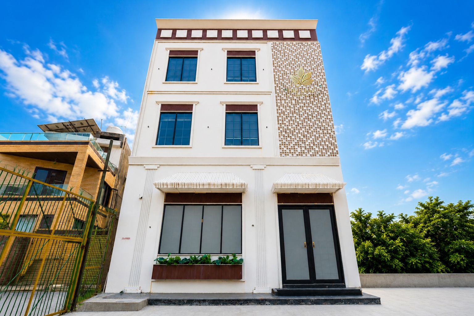 A modern two-story building with a flat roof, large windows, and a decorative facade.