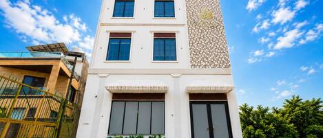 A modern two-story building with a flat roof, large windows, and a decorative facade.